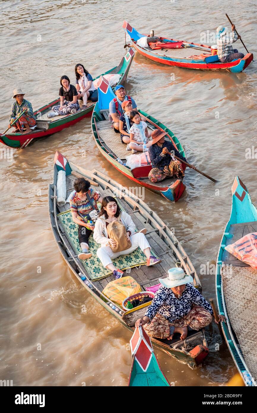 Les femmes locales invitent les touristes à profiter d'une promenade en bateau à travers les marais et les rivières de la jungle à la limite du lac Tonle SAP, Kampong Phluk, Cambodge. Banque D'Images