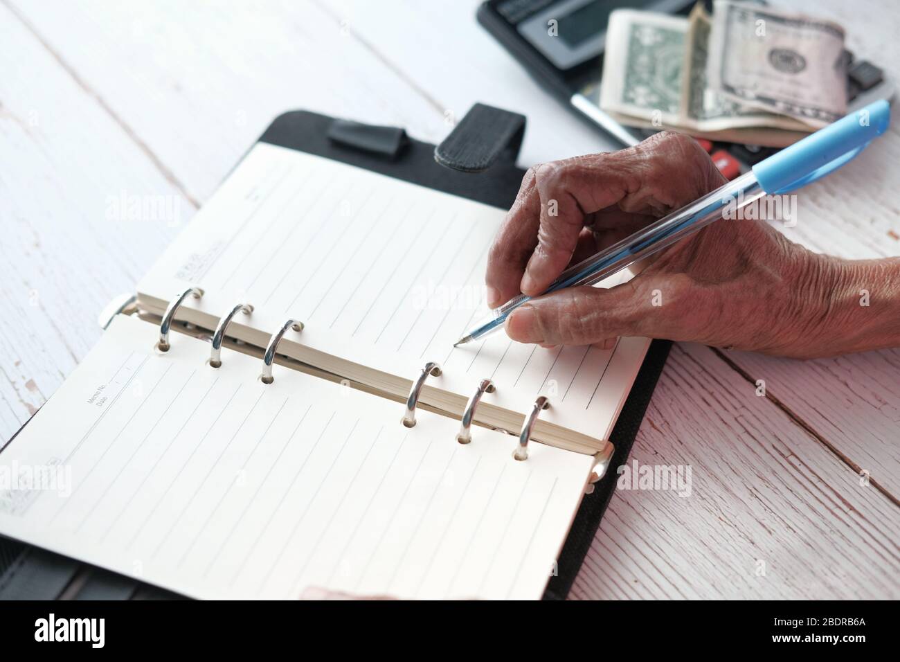 Gros plan sur l'écriture de main de femmes âgées sur le bloc-notes. Banque D'Images