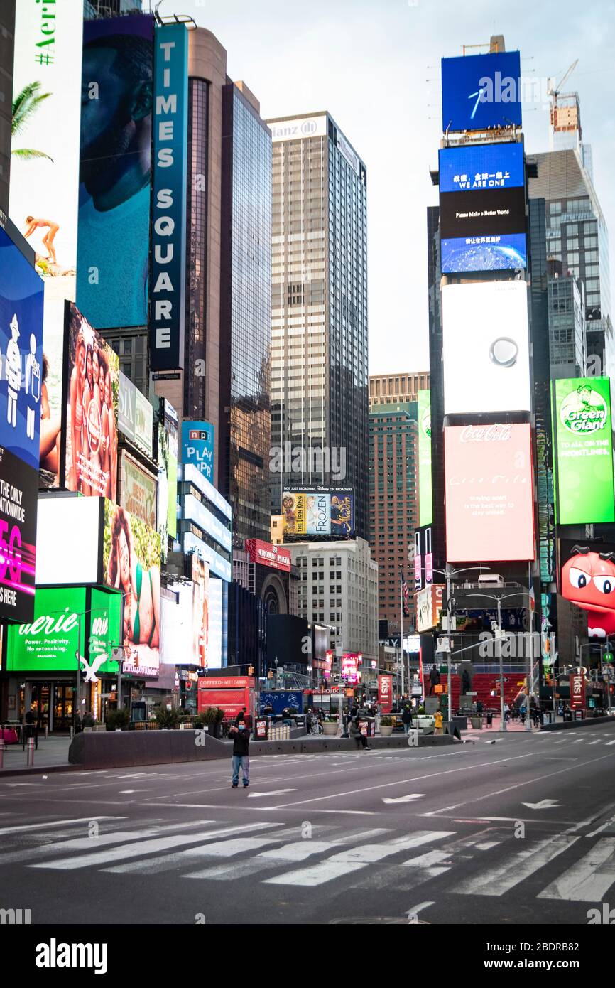 Un homme se tient au milieu de Times Square, vide et vide de touristes; comme les entreprises ont été fermées pour empêcher la propagation de COVID-19. Banque D'Images