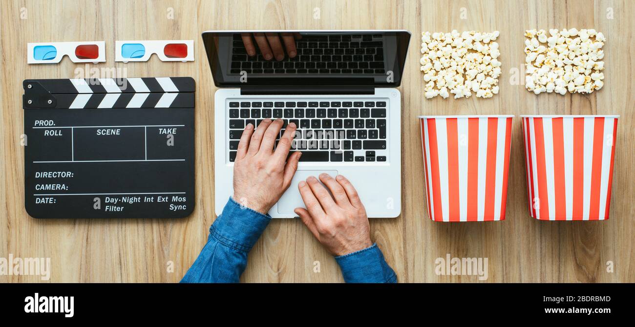 Homme qui regarde un film en streaming en ligne avec popcorn, lunettes 3D  et Clap, cinéma et divertissement concept, mise à plat Photo Stock - Alamy