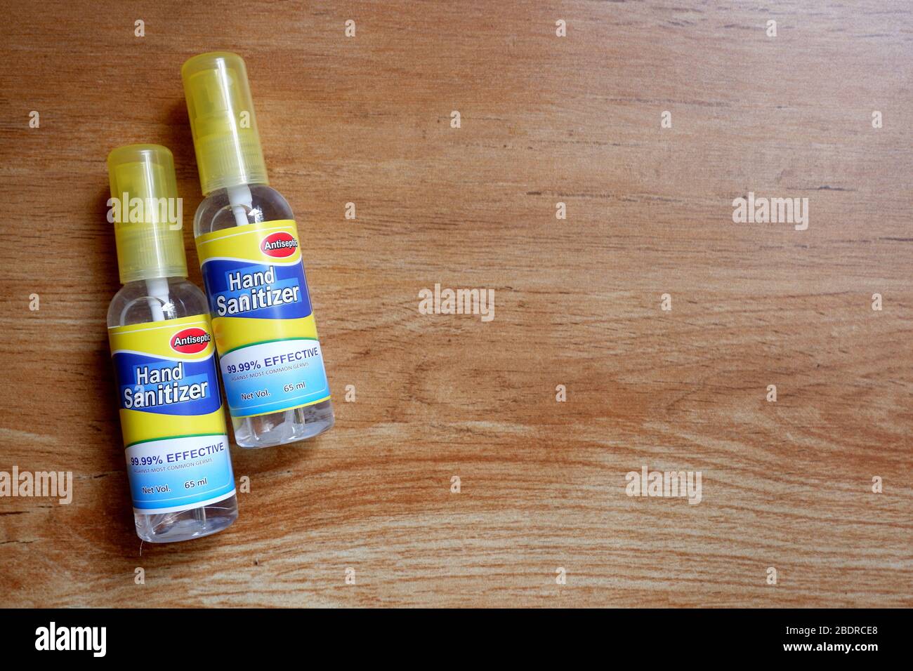 Deux bouteilles de désinfectant pour les mains sur un socle en bois. Banque D'Images