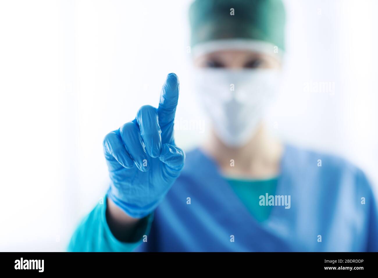 Chirurgien féminin utilisant une interface à écran tactile, elle pointe avec son doigt, la santé et le concept technologique Banque D'Images