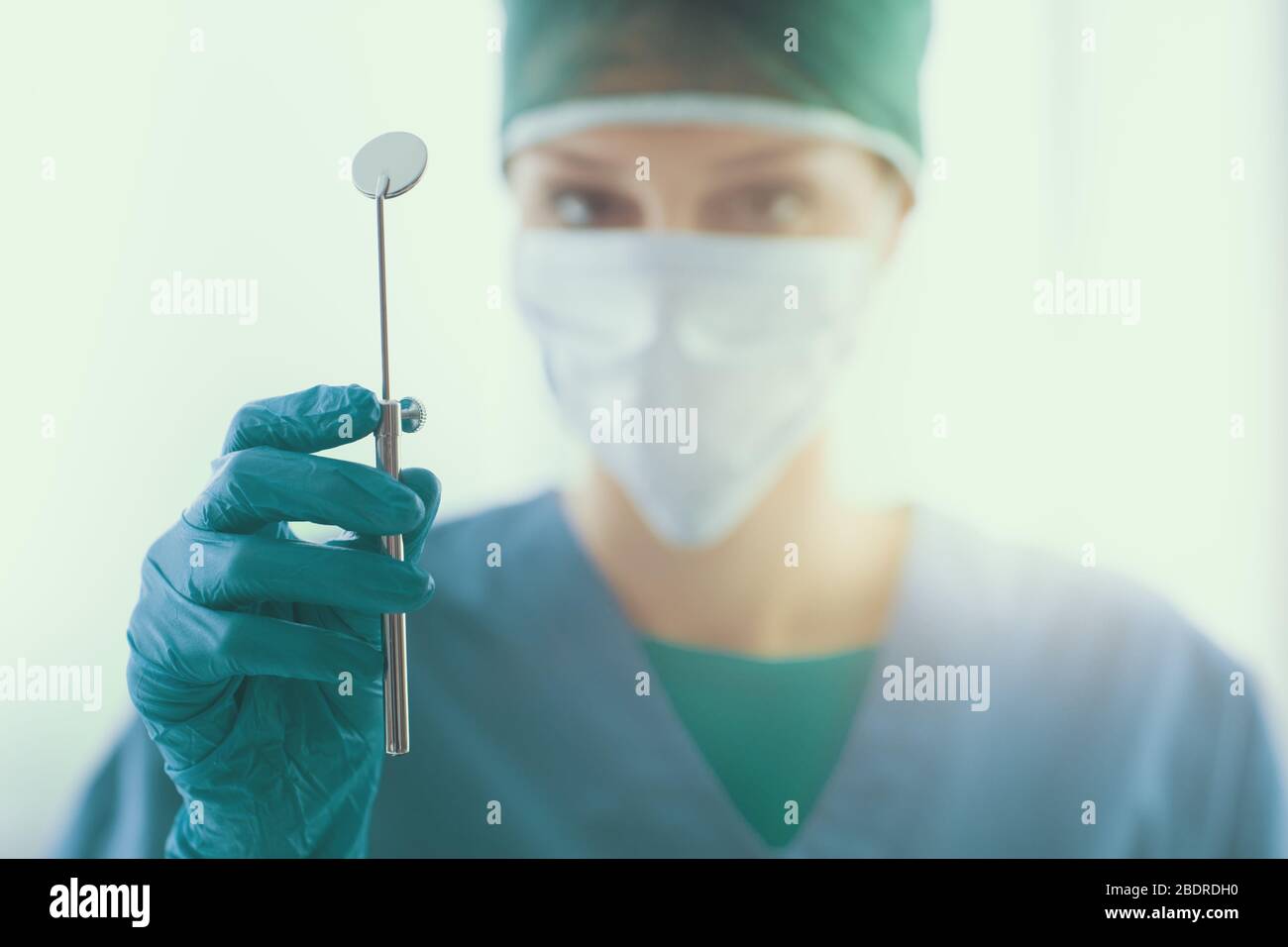 Femme dentiste prêts pour l'opération et tenant un miroir de la bouche Banque D'Images