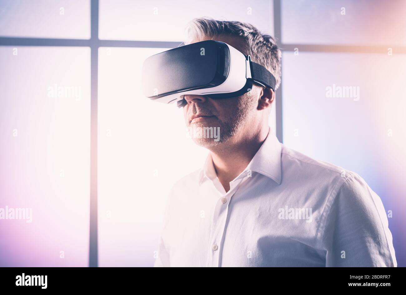 Homme d'âge mûr connaissant la réalité virtuelle, il porte un casque VR, une technologie et un concept d'innovation Banque D'Images