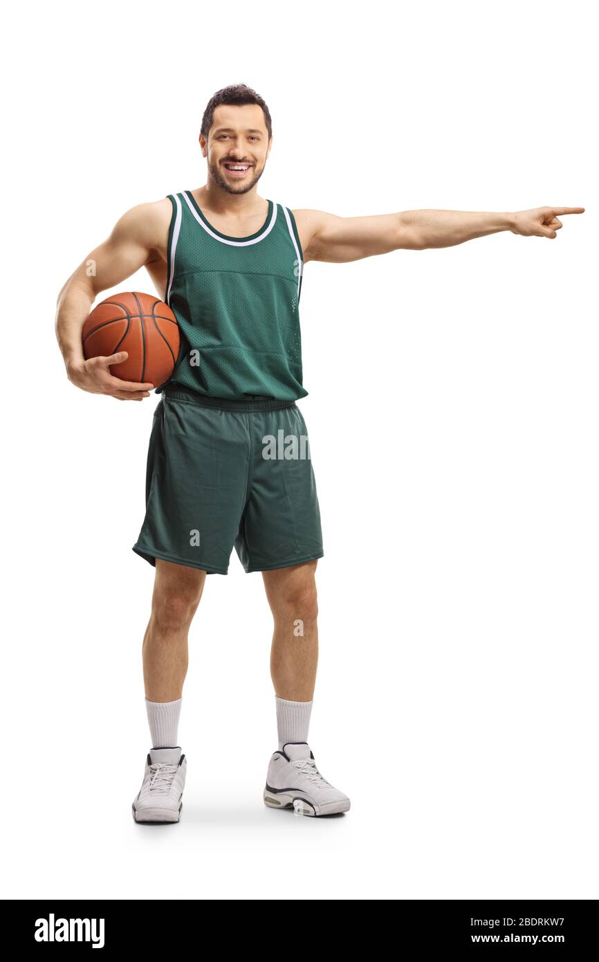 Portrait complet d'un joueur de basket-ball tenant une balle et pointant vers le côté isolé sur fond blanc Banque D'Images
