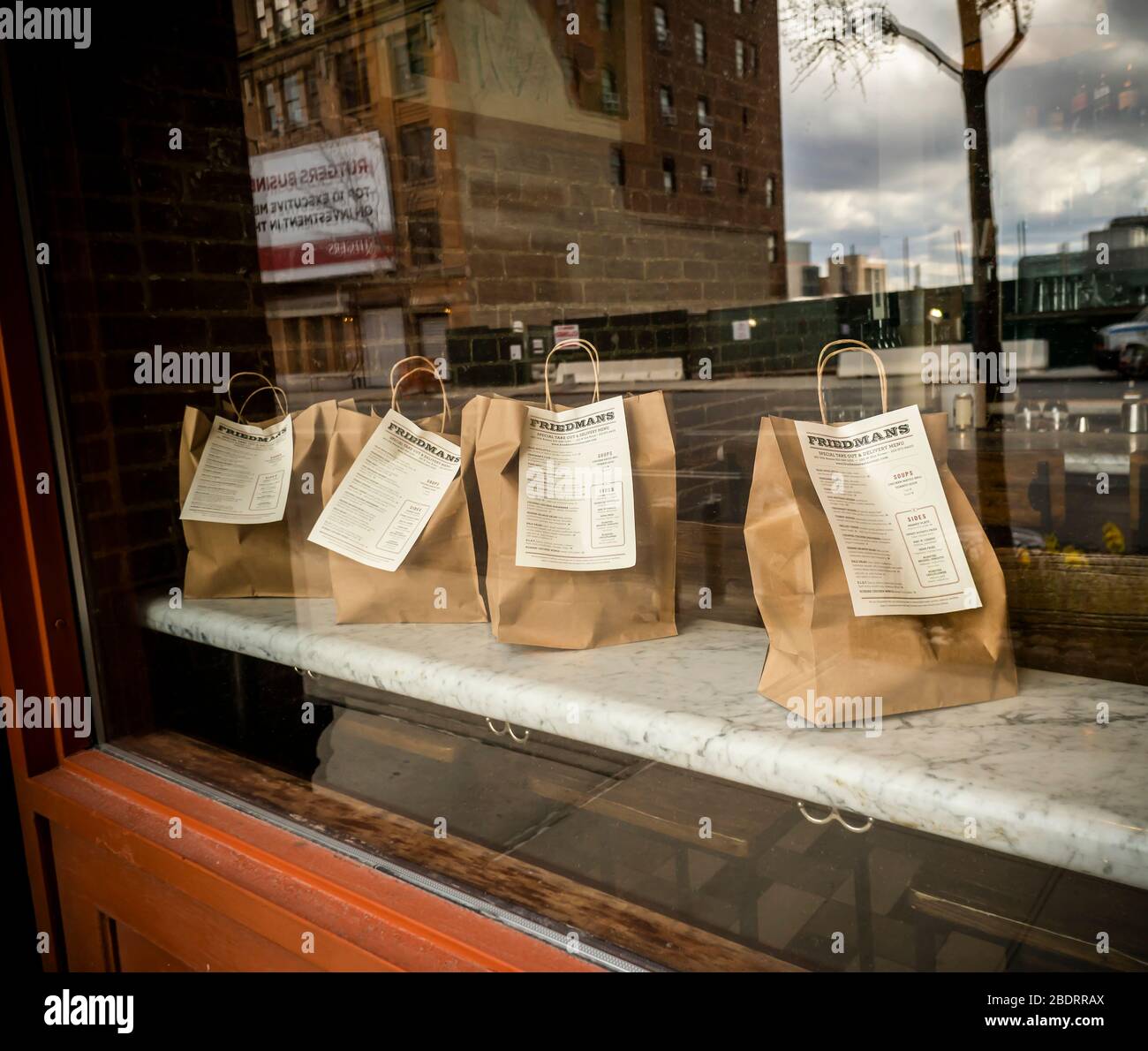 Commandes en attente de prise en charge et de livraison dans la fenêtre d'un restaurant dans le quartier de Hell’s Kitchen de New York le mercredi 8 avril 2020. (© Richard B. Levine) Banque D'Images