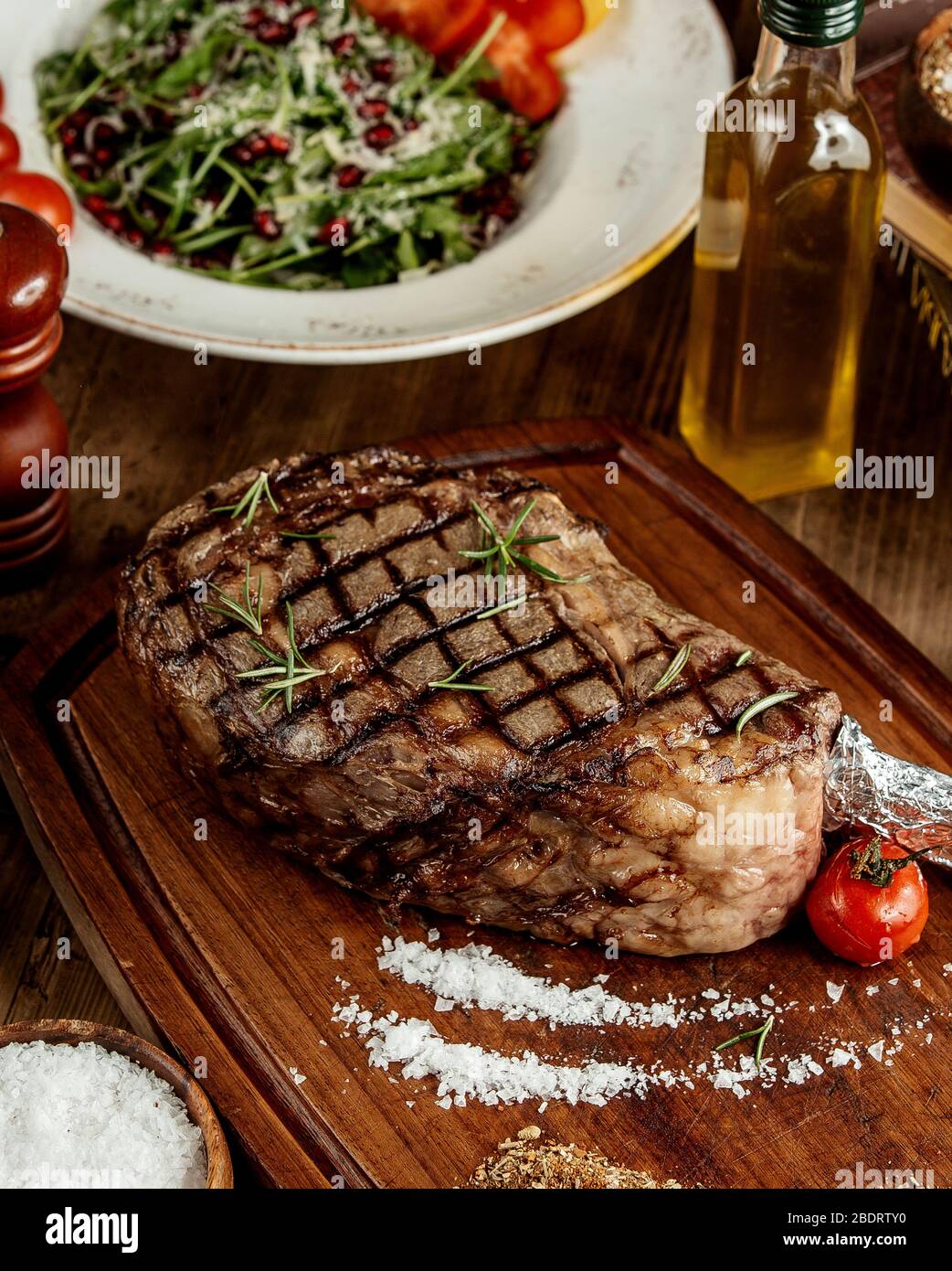 bifteck grillé aux herbes salines et tomate grillée servi sur planche en bois Banque D'Images