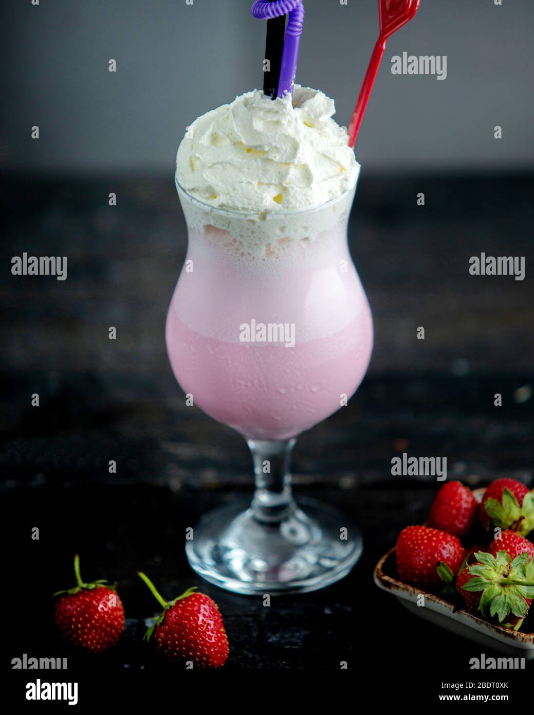 un verre de milkshake de fraise garni de crème fouettée Banque D'Images