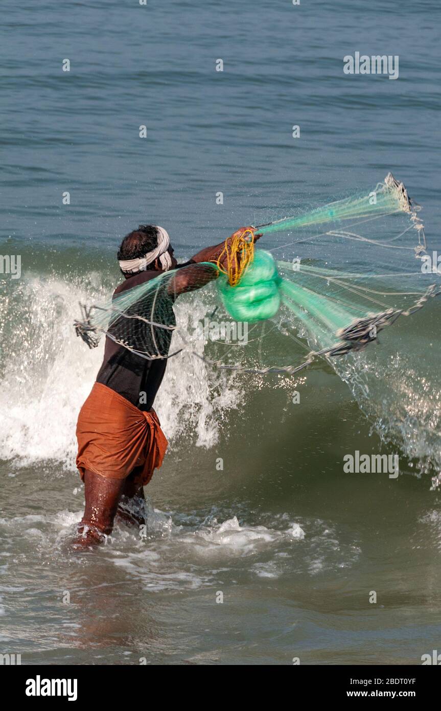 Pêcheur jetant un filet sur la plage de Marari, Mararikulam, Alapuzha District, Kerala, Inde Banque D'Images