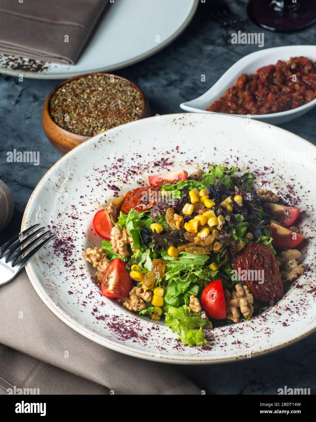 une assiette de salade verte avec du maïs de tomates de laitue et du raisin Banque D'Images