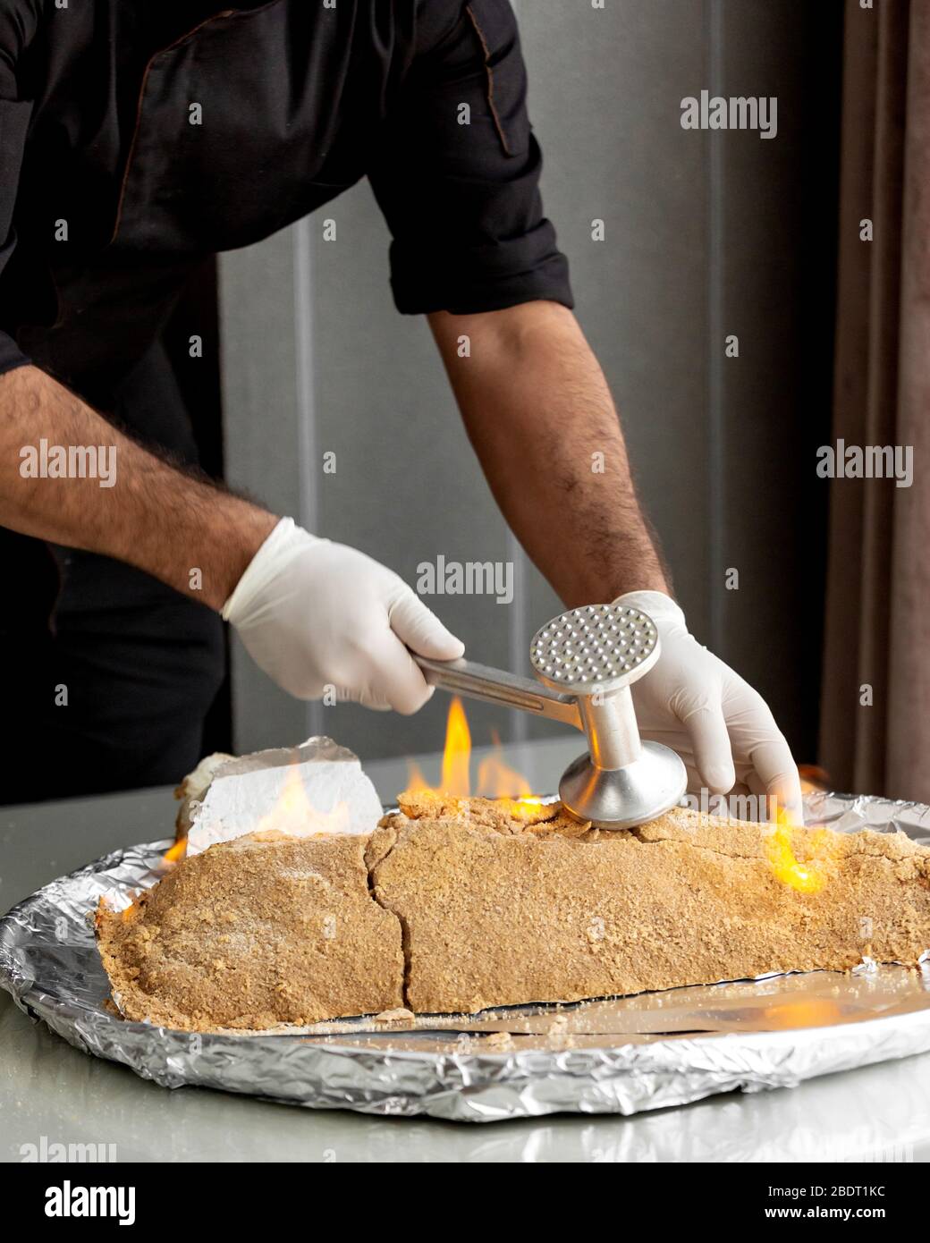 chef brisant le poisson brûlé en croûte de sel avec un tensioactif en acier Banque D'Images