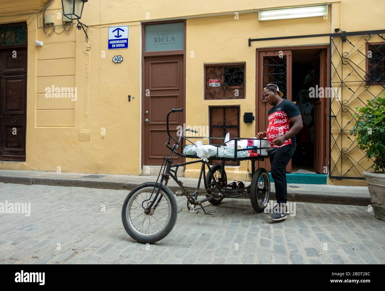 En dehors de l'Hostal Conde de Ricla avec trike de livraison et livrant des marchandises, Calle San Ignacio 402 entre sol y Muralla, la Havane Cuba Banque D'Images