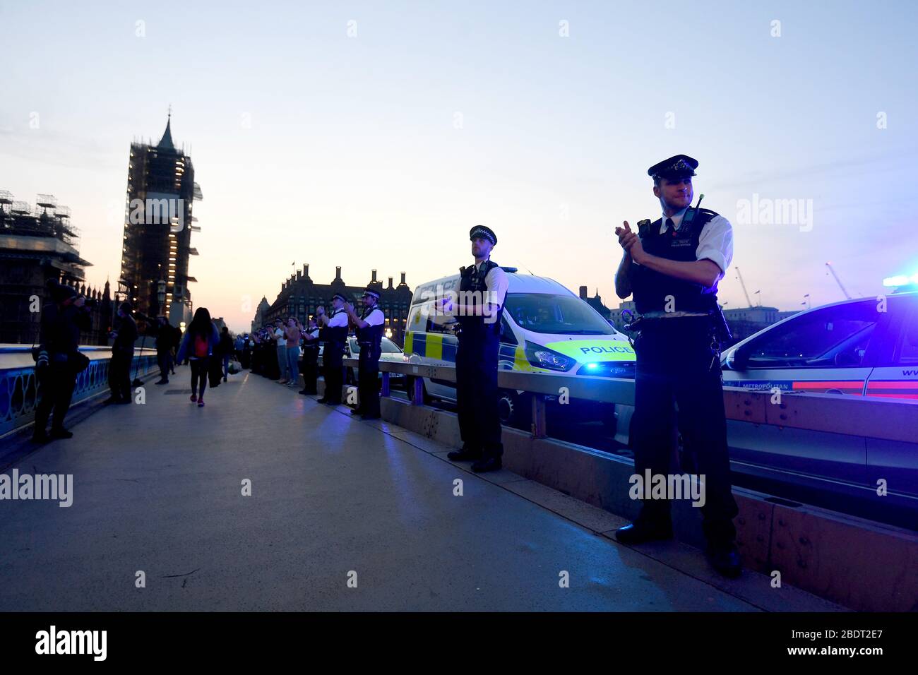 Les officiers de la police métropolitaine applaudissent sur le pont de Westminster à Londres pour saluer les héros locaux au cours de l'initiative nationale de Clap pour les soignants NHS de jeudi pour applaudir les travailleurs du NHS qui luttent contre la pandémie de coronavirus. Banque D'Images