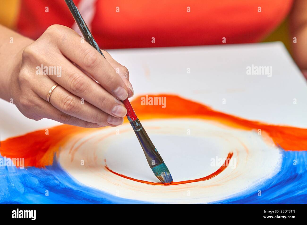 L'artiste peint le paysage dans la gouache à l'aide d'une brosse. La main de la femme tient la brosse. Gros plan, mise au point sélective Banque D'Images