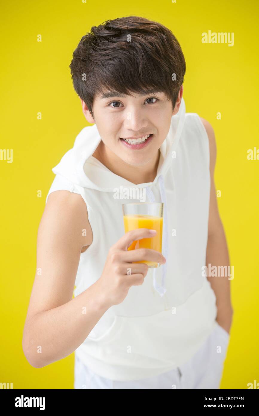 Jeunes hommes dynamiques avec jus d'orange Banque D'Images