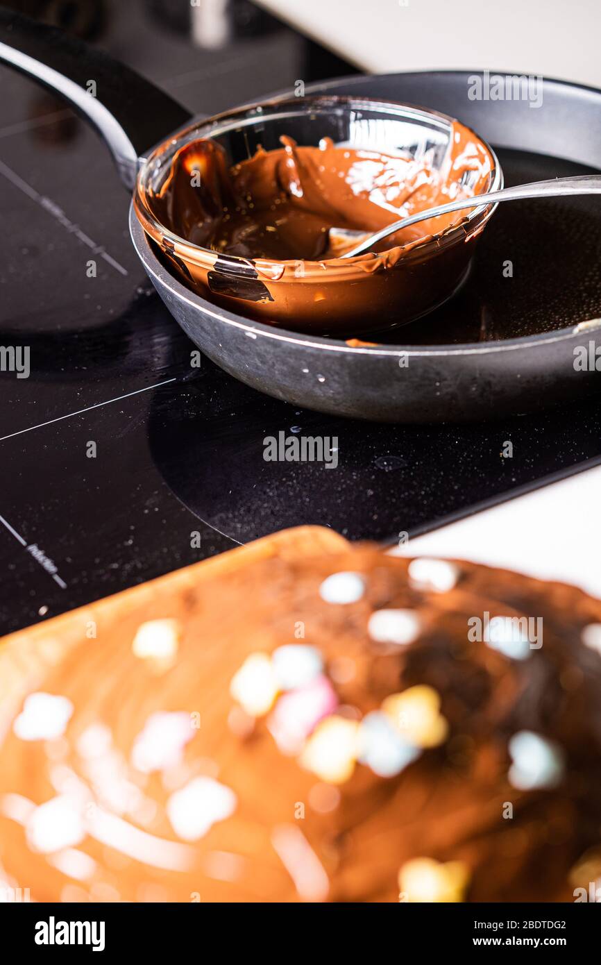 Le chocolat chaud a fondu sur une poêle noire avec gâteau au chocolat au premier plan Banque D'Images