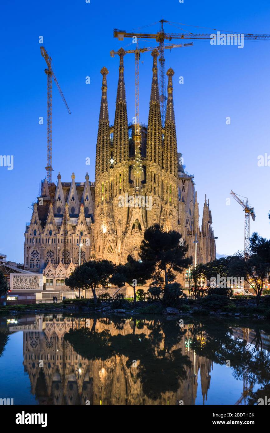 Vue sur la Nativité face de la basilique de la Sagra Familia reflétée dans le lac de la Placa de Gaudi, Barcelone, Espagne. Banque D'Images