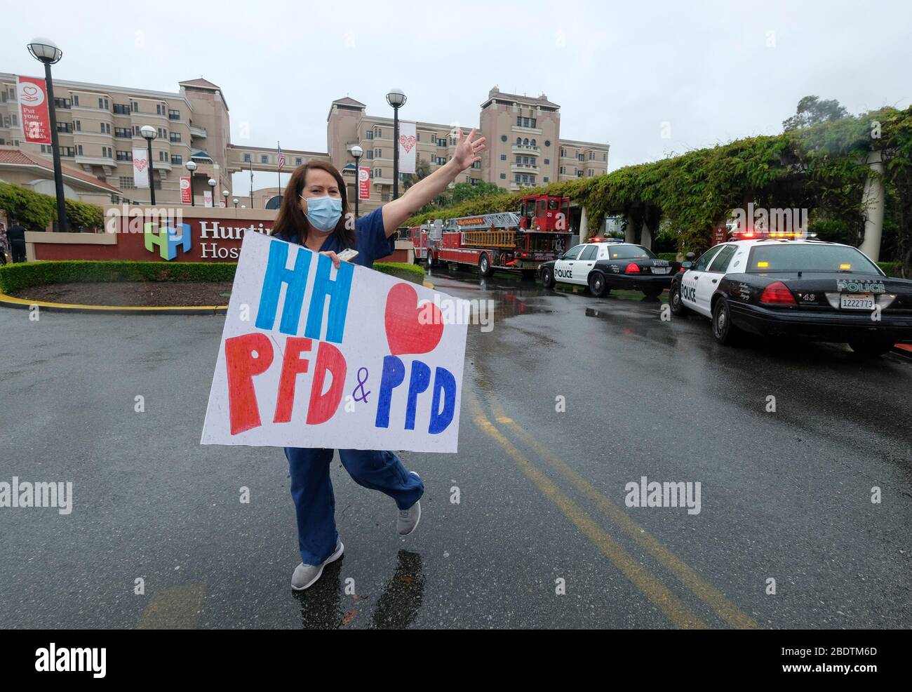 Los Angeles, Californie, États-Unis. 9 avril 2020. Un professionnel de la santé qui tient une pancarte accueille les policiers et le personnel du service d'incendie de Pasadena à l'avant de l'hôpital Huntington avec des lampes d'urgence et des sirènes activées pour montrer leur appréciation aux travailleurs de la santé dans la salle d'urgence et dans tout l'hôpital de Pasadena, Californie, le jeudi 9 avril 2020. Crédit: Ringo Chiu/ZUMA Wire/Alay Live News Banque D'Images