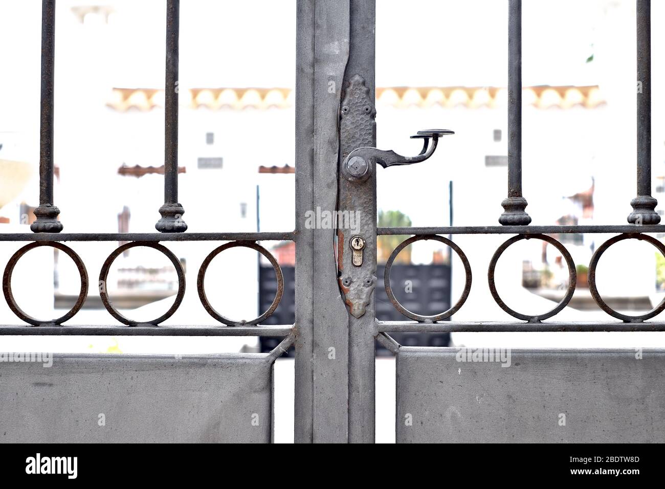 Porte en acier forgé avec bars, poignée et serrure, verrouillée, entrée à une ancienne villa méditerranéenne classique. Banque D'Images