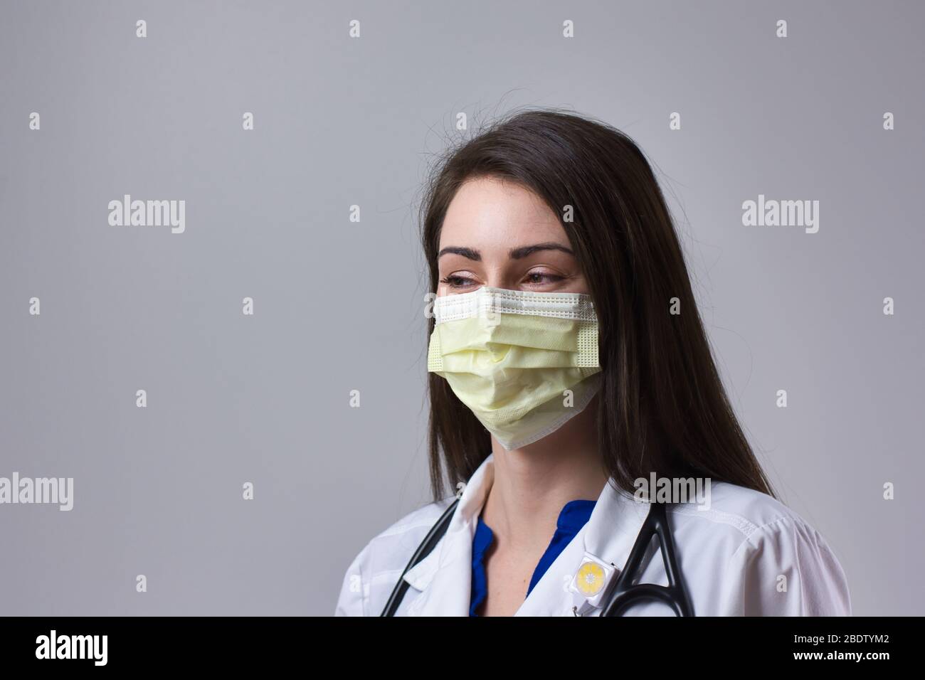 Masque de port professionnel de la médecine avec fond gris. Médecin portant un stéthoscope autour de son cou. Médecin féminin Banque D'Images