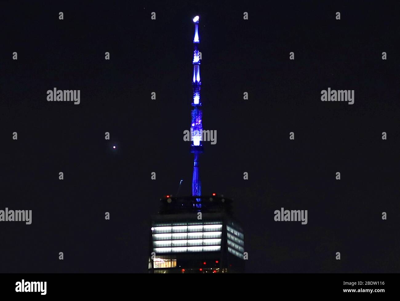 New York, États-Unis. 9 avril 2020. Planet venus se déplace derrière un World Trade Center alors que sa spire est allumée en bleu à New York le jeudi 9 avril 2020. Plus de 150 bâtiments dans tout le pays ont allumé en bleu ce soir à 20:00 heure locale en solidarité avec les travailleurs de l'hôpital et les premiers intervenants qui combattent COVID-19. Photo de John Angelillo/UPI crédit: UPI/Alay Live News Banque D'Images