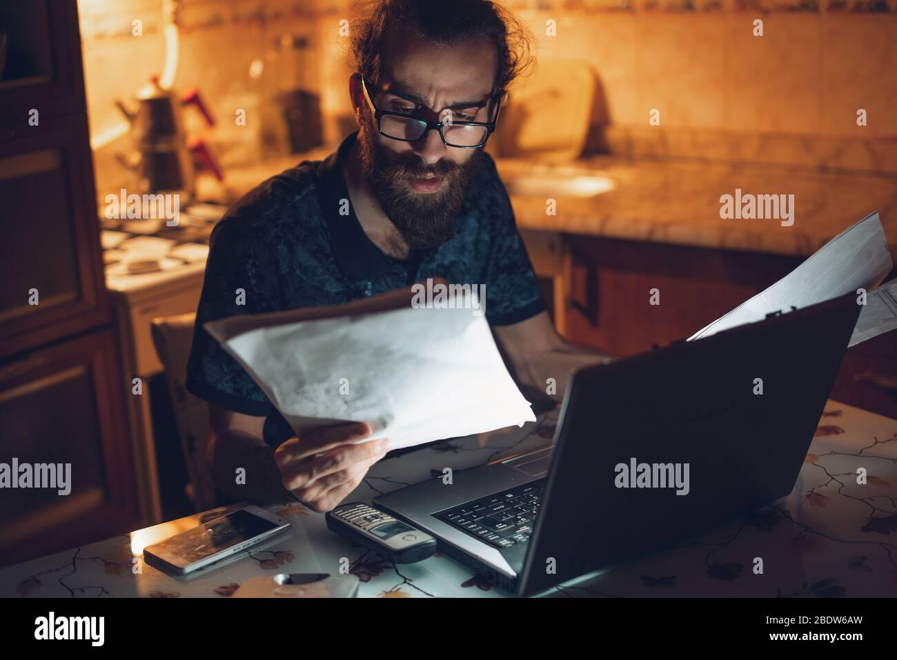 Un homme barbu de cheveux longs et de jeunes hipsters stressés vérifie la facture dans la cuisine.facture et finance. Banque D'Images