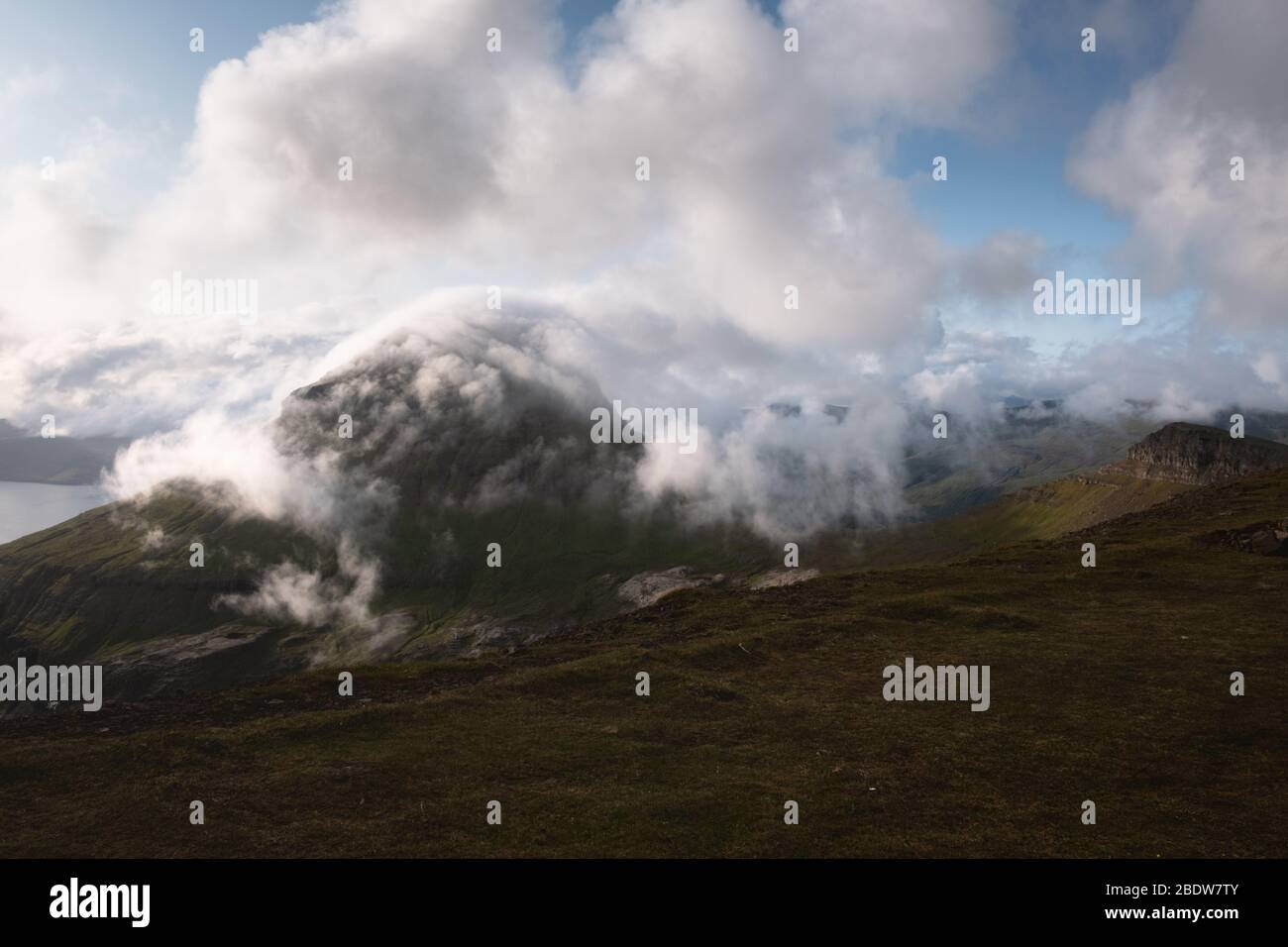 Pics de montagne brumeux et nuages couvrant la mer et les montagnes. Vue de la célèbre place - Sornfelli sur l'île de Streymoy, îles Féroé, Danemark. Photographie de paysage Banque D'Images