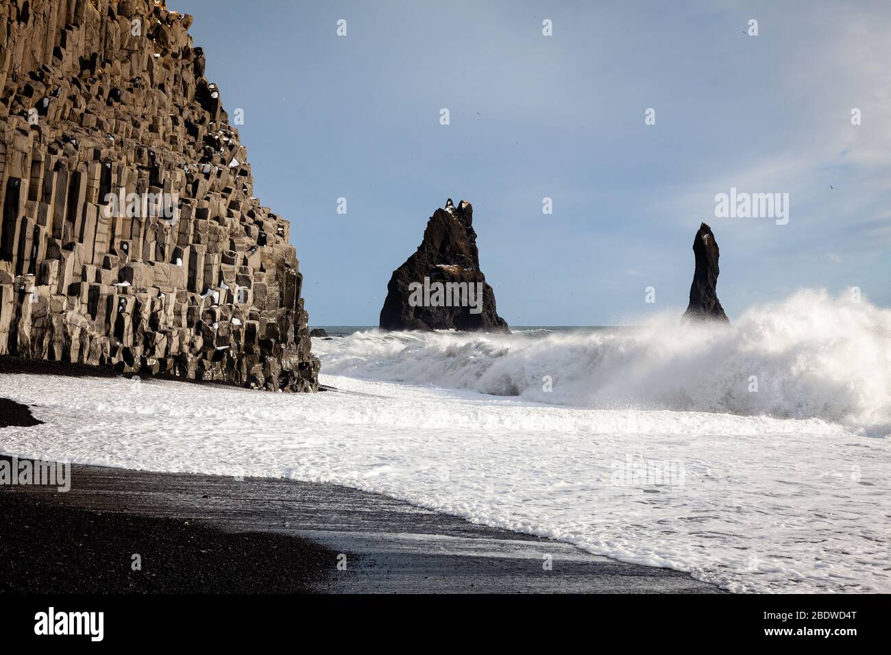 Reynisdrangar piles de mer et colonnes de basalte à Reynisfjara plage de sable noir en hiver près de Vík í Mýrdal, au sud de l'Islande Banque D'Images