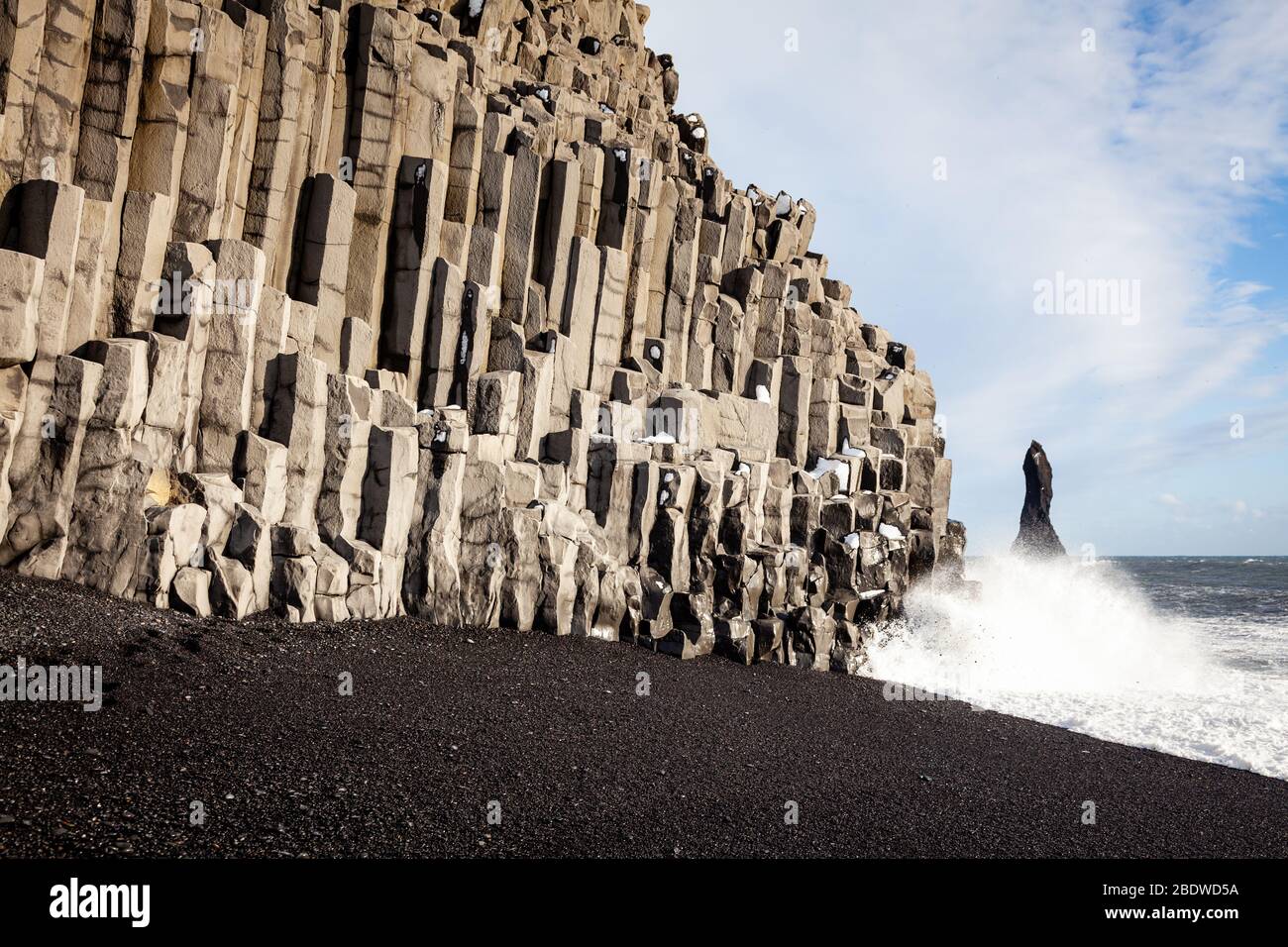Reynisdrangar piles de mer et colonnes de basalte à Reynisfjara plage de sable noir en hiver près de Vík í Mýrdal, au sud de l'Islande Banque D'Images