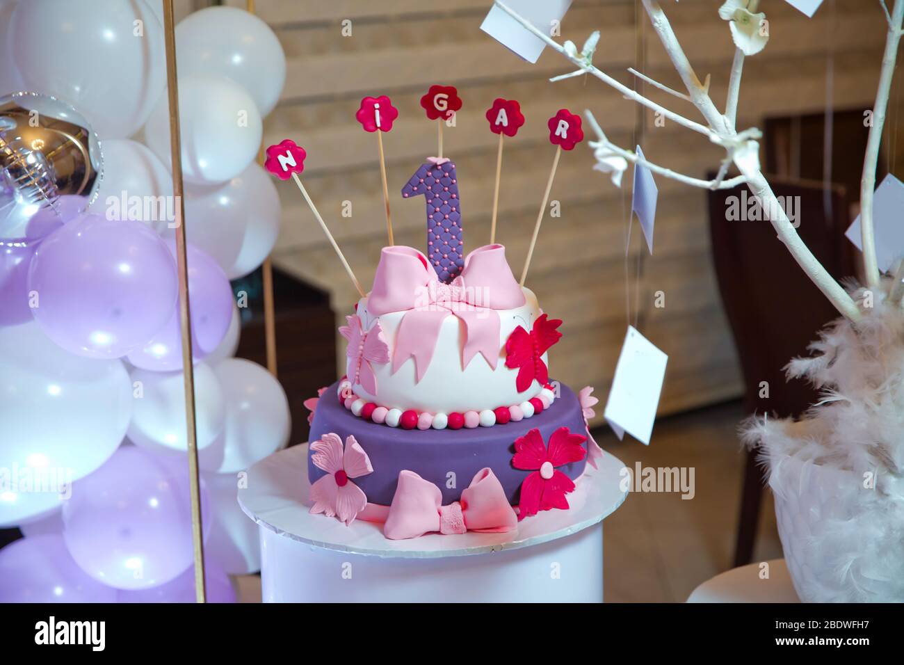 Inscription Nigar avec bougies . Une inscription violette. Un gâteau d'anniversaire humide. Banque D'Images