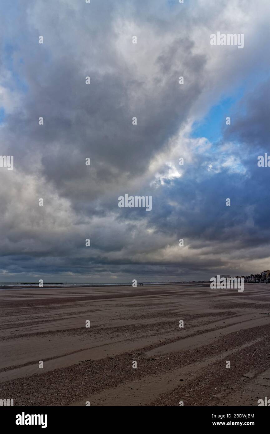 Dunkerque Beach et front de mer avec des gens qui marchent le long de lui sous un ciel spectaculaire sur un vent de novembre matin. Banque D'Images