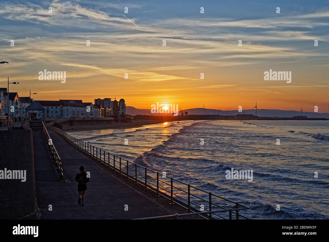 Le soleil se lève sur les dunes de sable et les grues de Swansea Bay, marquant le début d'une autre journée chaude et ensoleillée au sud du Pays de Galles, au Royaume-Uni. Mercredi 25 mars 2020 Banque D'Images