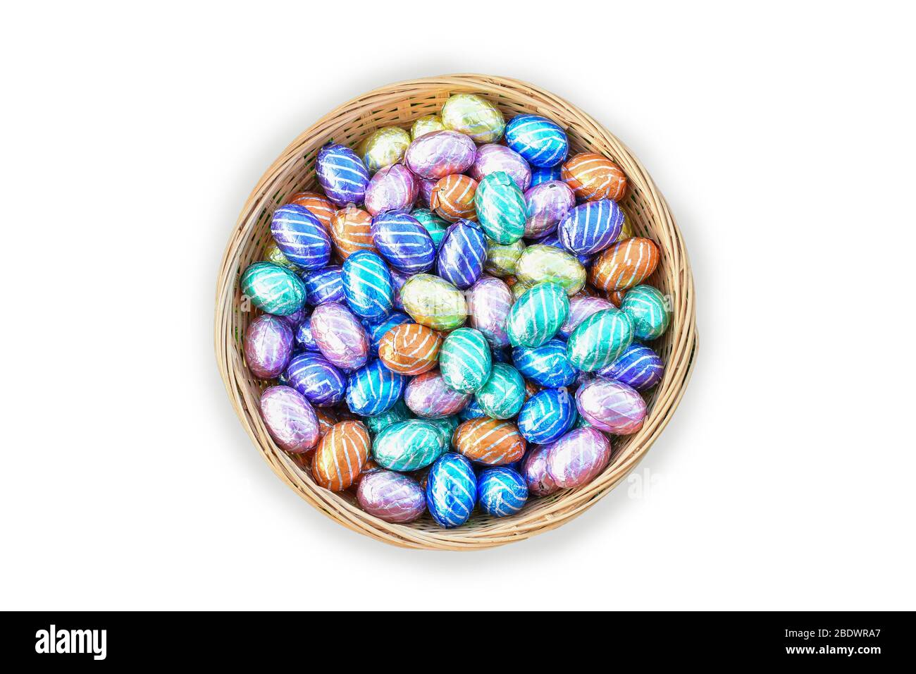 Oeufs de Pâques au chocolat coloré dans le panier isolé sur fond blanc. Banque D'Images
