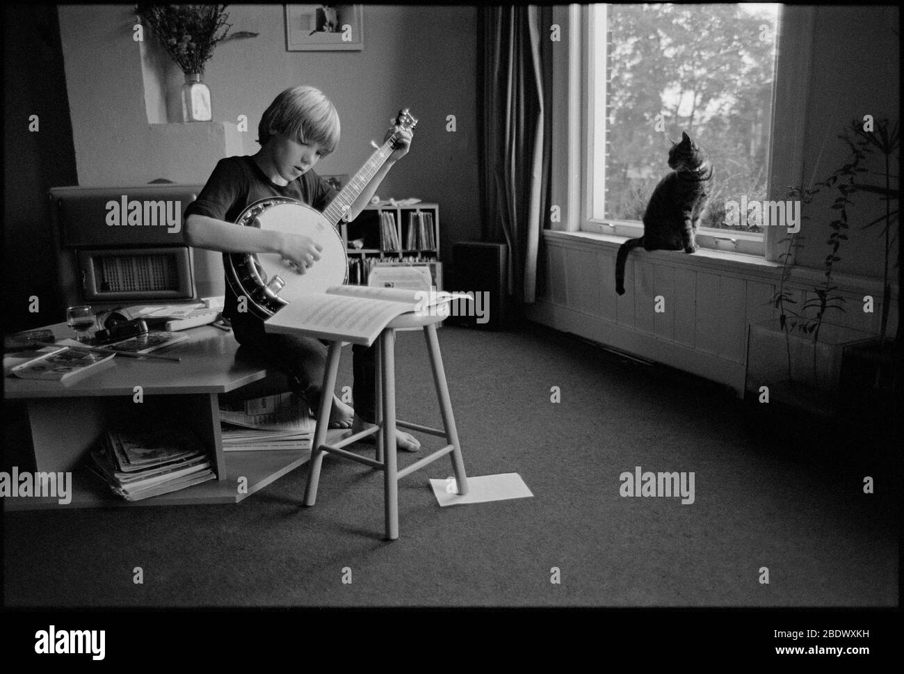 Photo noir et blanc vintage d'un petit garçon qui pratique le banjo Banque D'Images