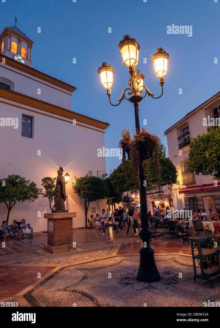 Les gens qui mangent sur une place pavée dans la vieille ville de Marbella, Marbella, Espagne. Banque D'Images