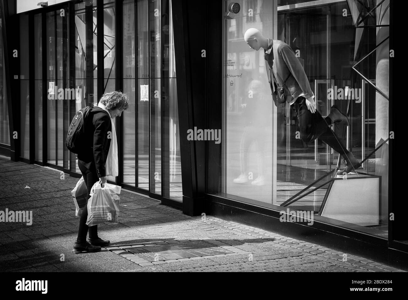 Femme et mannequin semblent lire une inscription dans une base de base ensemble sur la rue commerçante Schildergasse, Cologne, Allemagne. Frau und Schaufensterpup Banque D'Images
