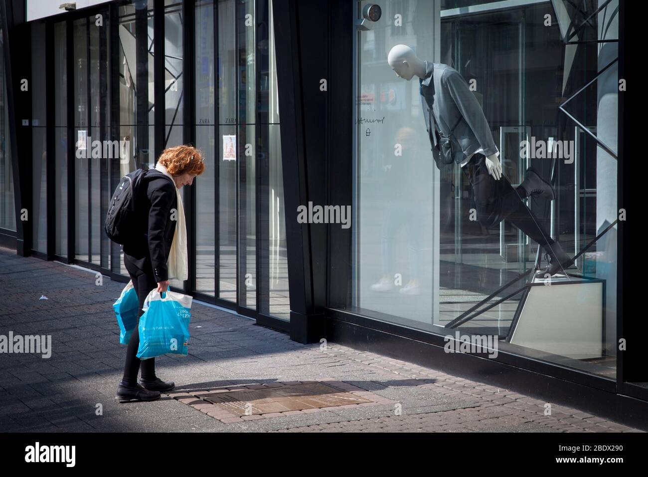 Femme et mannequin semblent lire une inscription dans une base de base ensemble sur la rue commerçante Schildergasse, Cologne, Allemagne. Frau und Schaufensterpup Banque D'Images