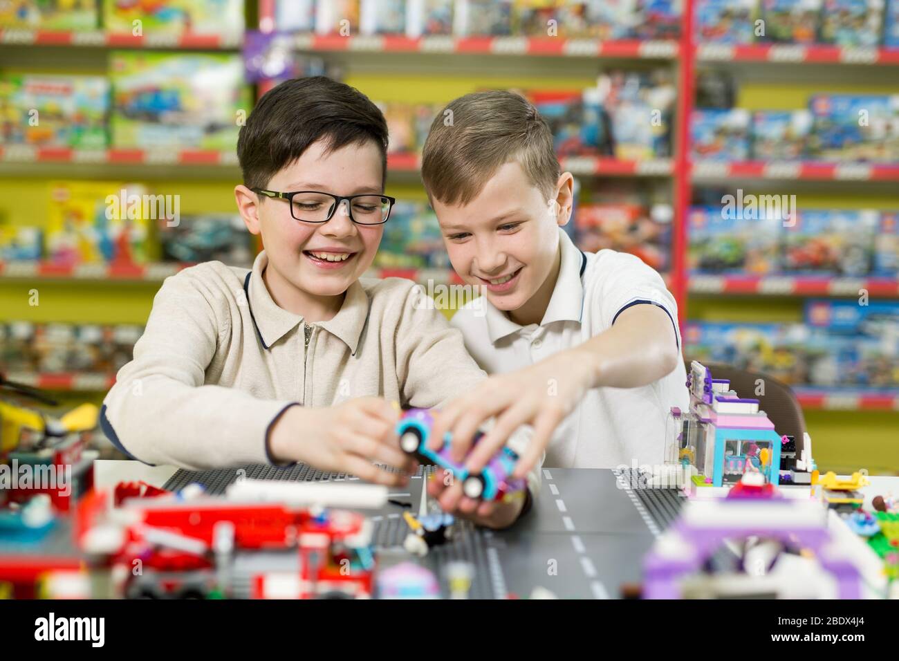 Les enfants jouent dans le concepteur à la table. Deux garçons jouent avec des blocs de plastique de couleur dans le centre de jeu, l'école Banque D'Images