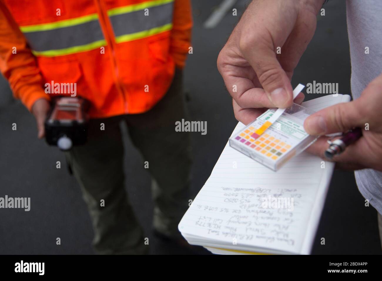 L'équipe américaine de protection de l'environnement (EPA) utilise des bandelettes d'essai de pH pour suivre la quantité de pluie acide dans l'air après l'éruption volcanique de Kīlauea, le 20 mai 2018. Dans le cadre d'une mission de la FEMA, l'EPA travaille avec le ministère de la Santé d'Hawaï pour aider les résidents à rester en sécurité en installant des stations de surveillance de l'air, qui fournissent des données sur le dioxyde de soufre, le sulfure d'hydrogène et les niveaux de particules. Banque D'Images