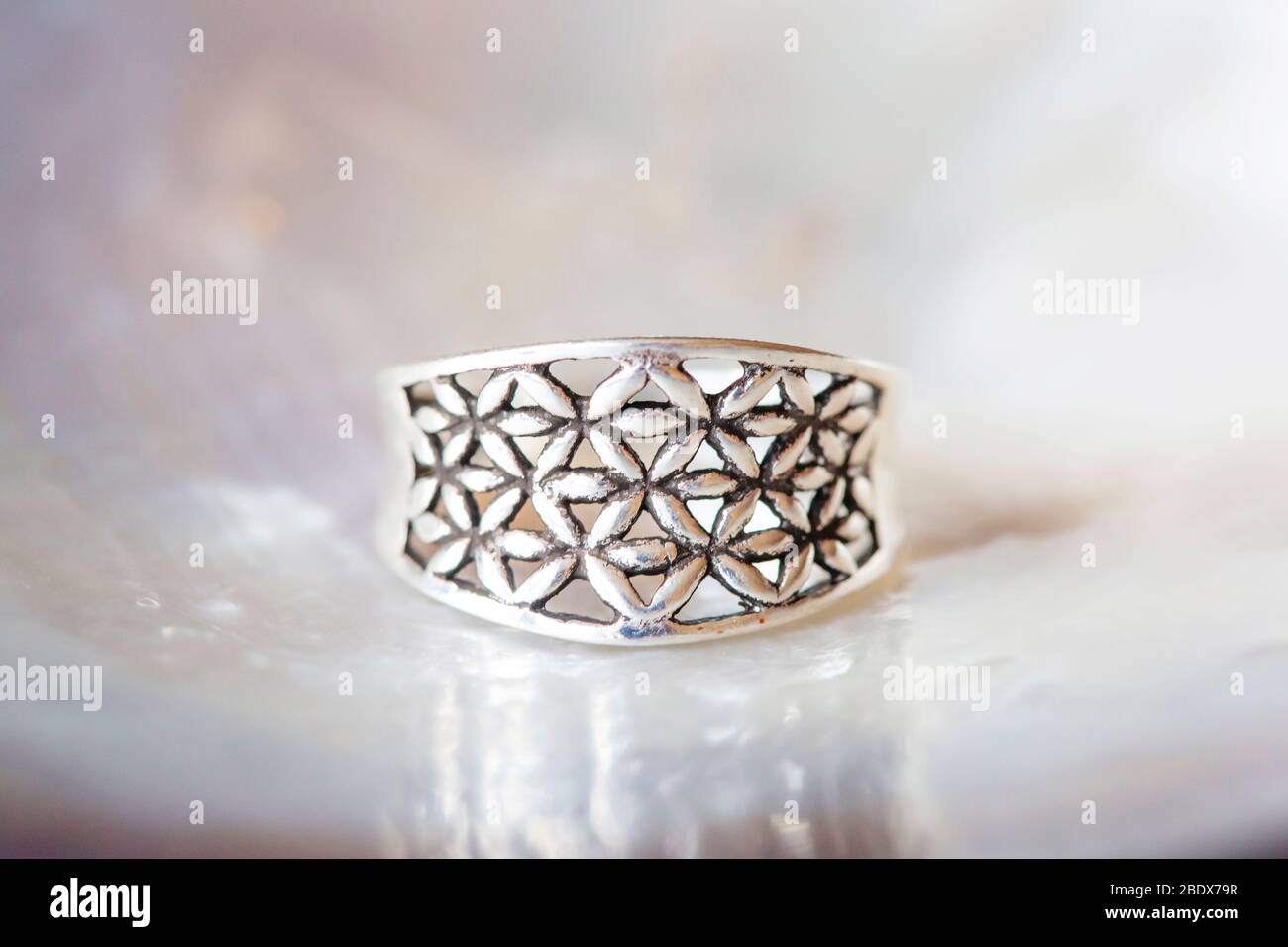 Bague argent petit bijou pièce sur fond blanc perle sous forme de fleur de  vie de géométrie sacrée Photo Stock - Alamy