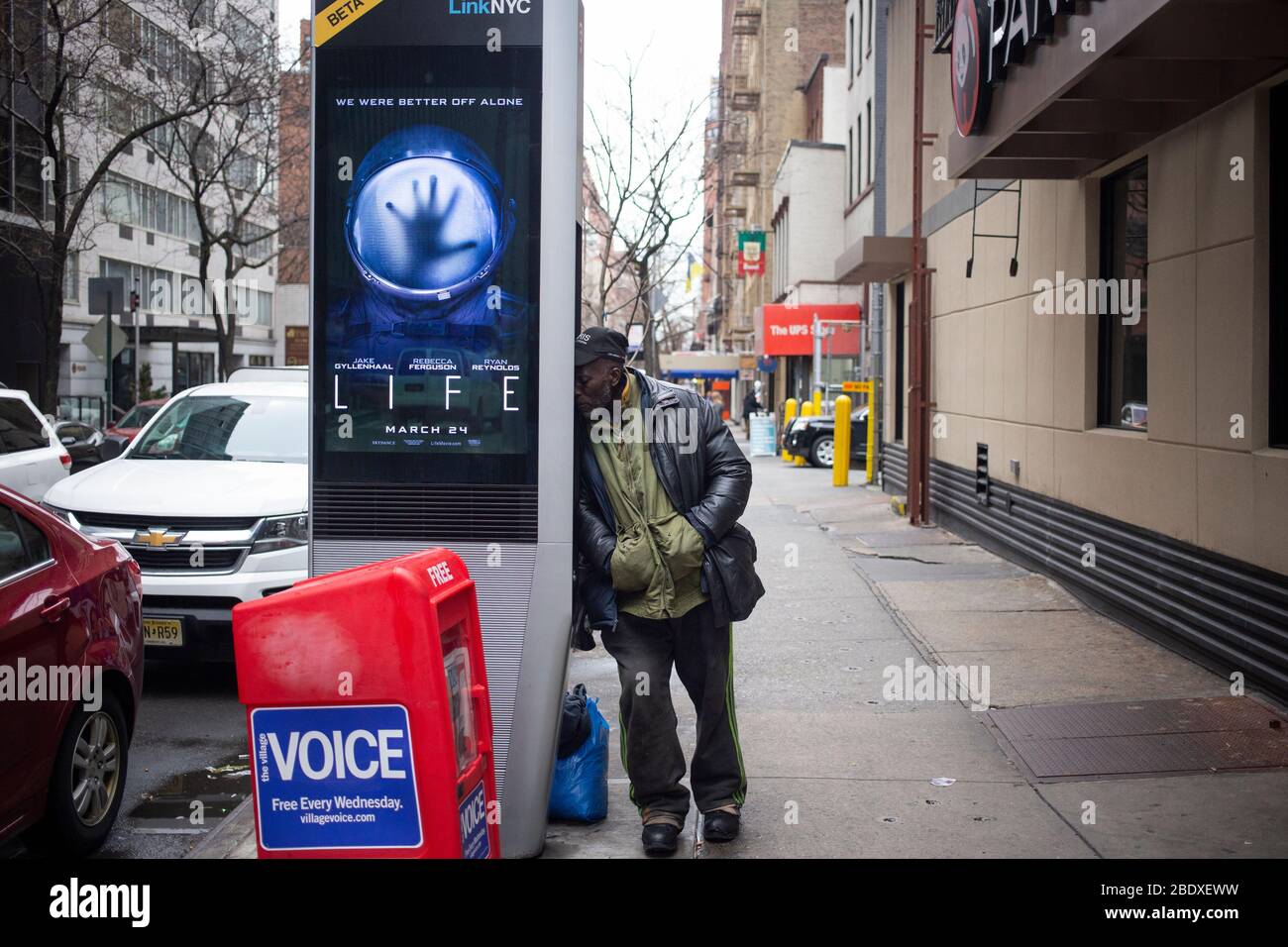 New York City, NY - 08 mars 2017: Un homme non identifié posant sur un point de chargement wifi dans une rue de New York City, NY Banque D'Images