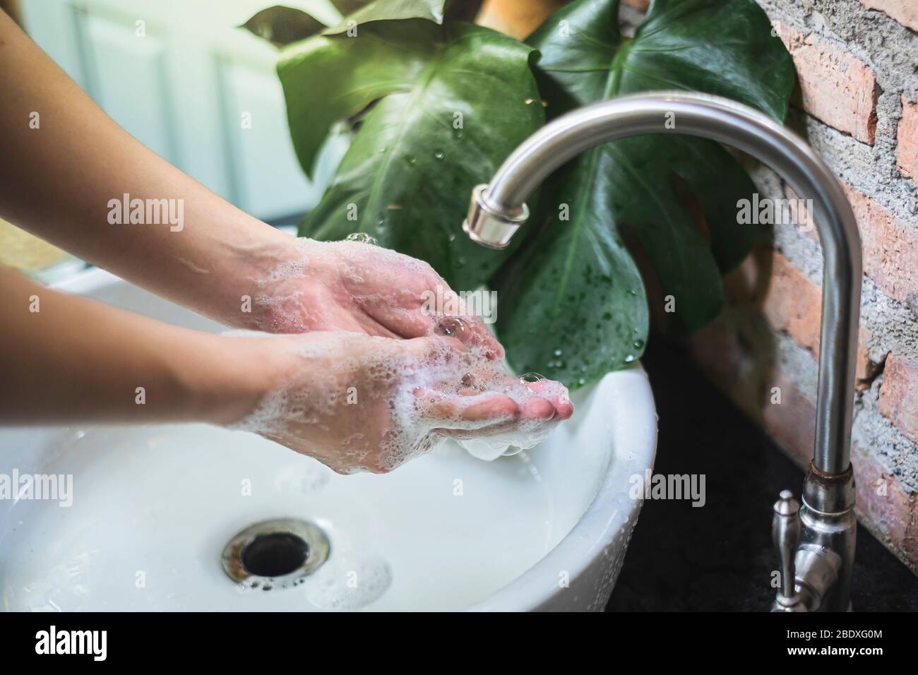 Le lavage et le frottement des mains avec du savon pendant plus de 20 secondes pourraient aider à prévenir la propagation des germes et du coronavirus (COVID-19). Banque D'Images