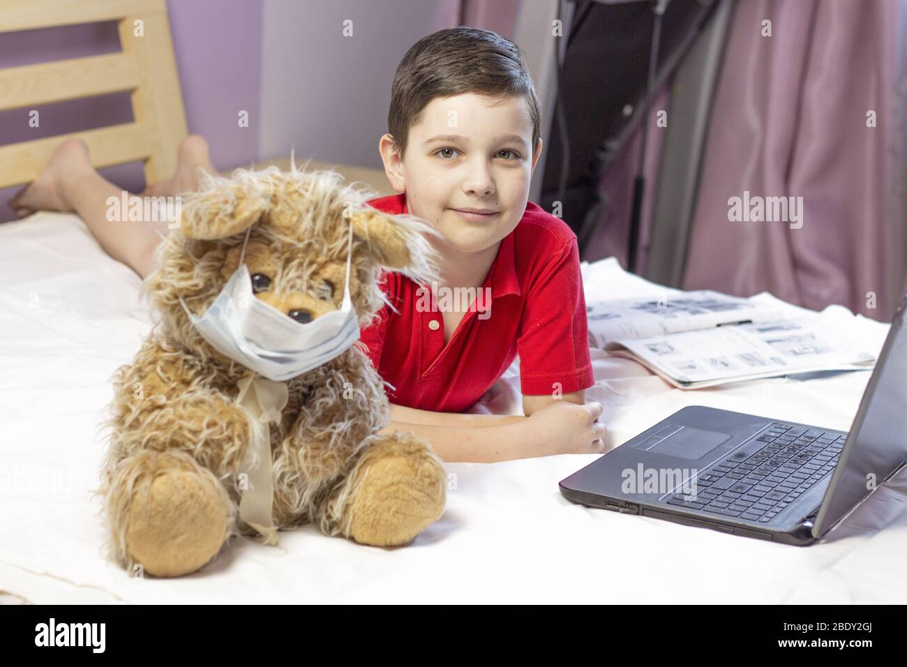 éducation en ligne de garçon. Accueil éducation. Quarantaine. Éducation en ligne. Cours d'informatique. Ours masqué. Coronavirus. copyspace Banque D'Images
