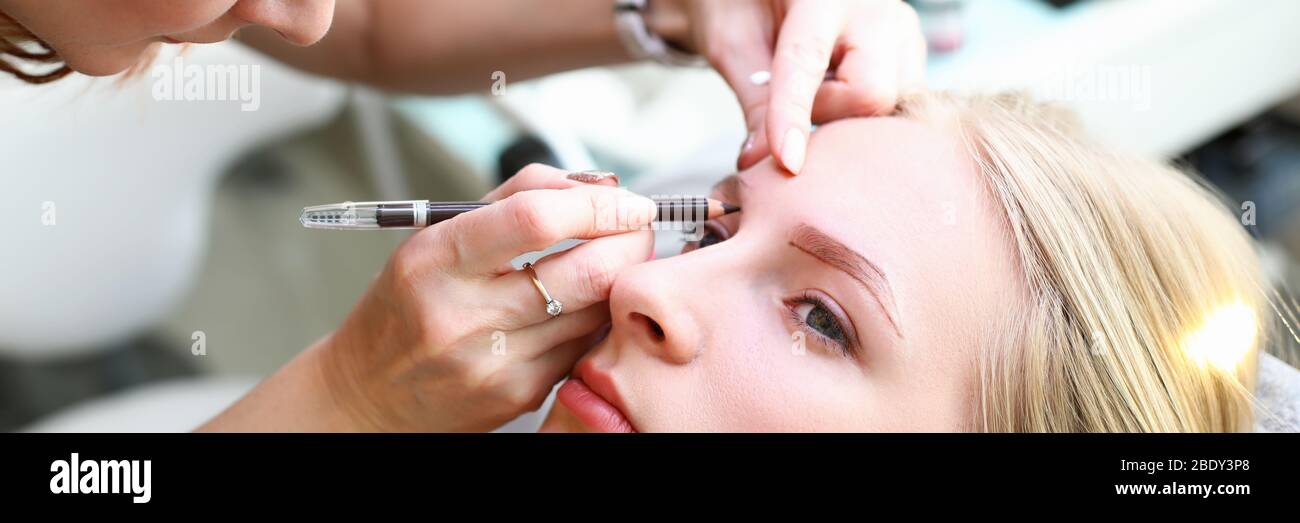 Femme qui fait le maquillage permanent Banque D'Images