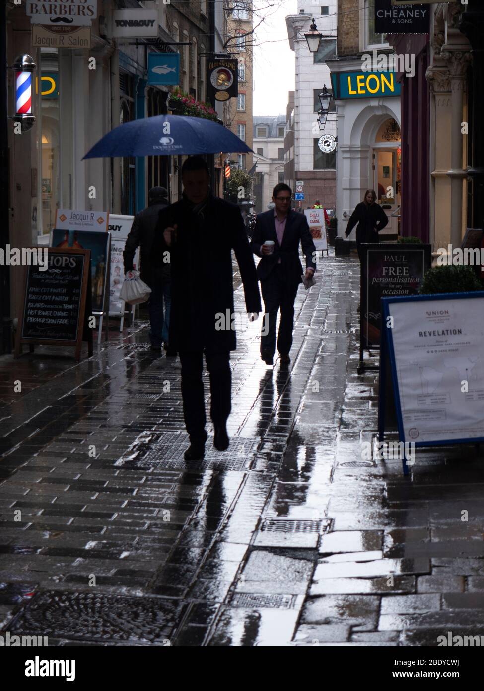 Midi, les piétons voyagent dans la ville de Bow Lane de Londres sous la pluie Banque D'Images