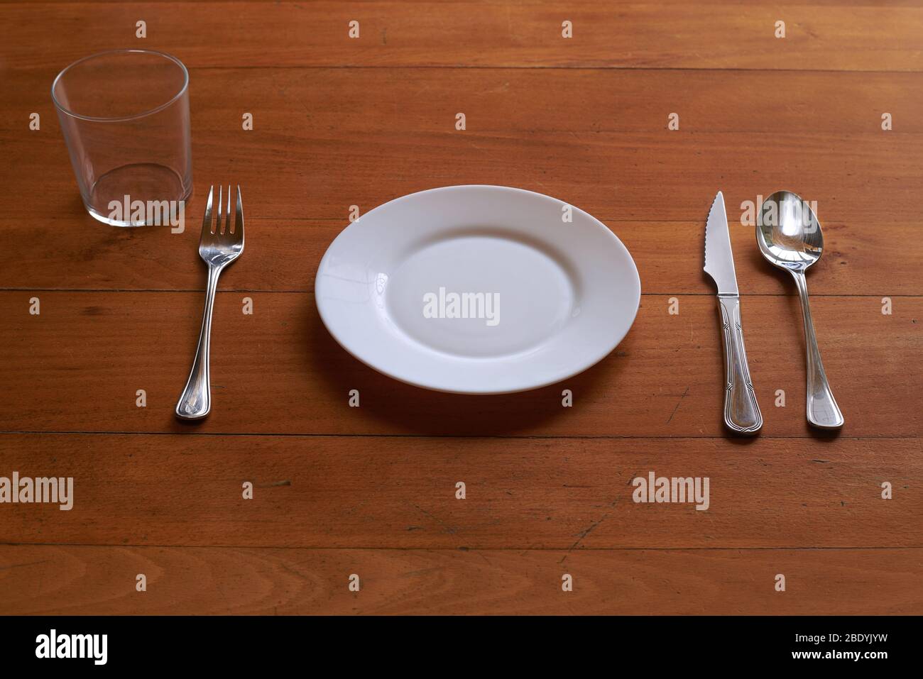 Petite assiette en porcelaine et coutellerie sur fond de bois Banque D'Images