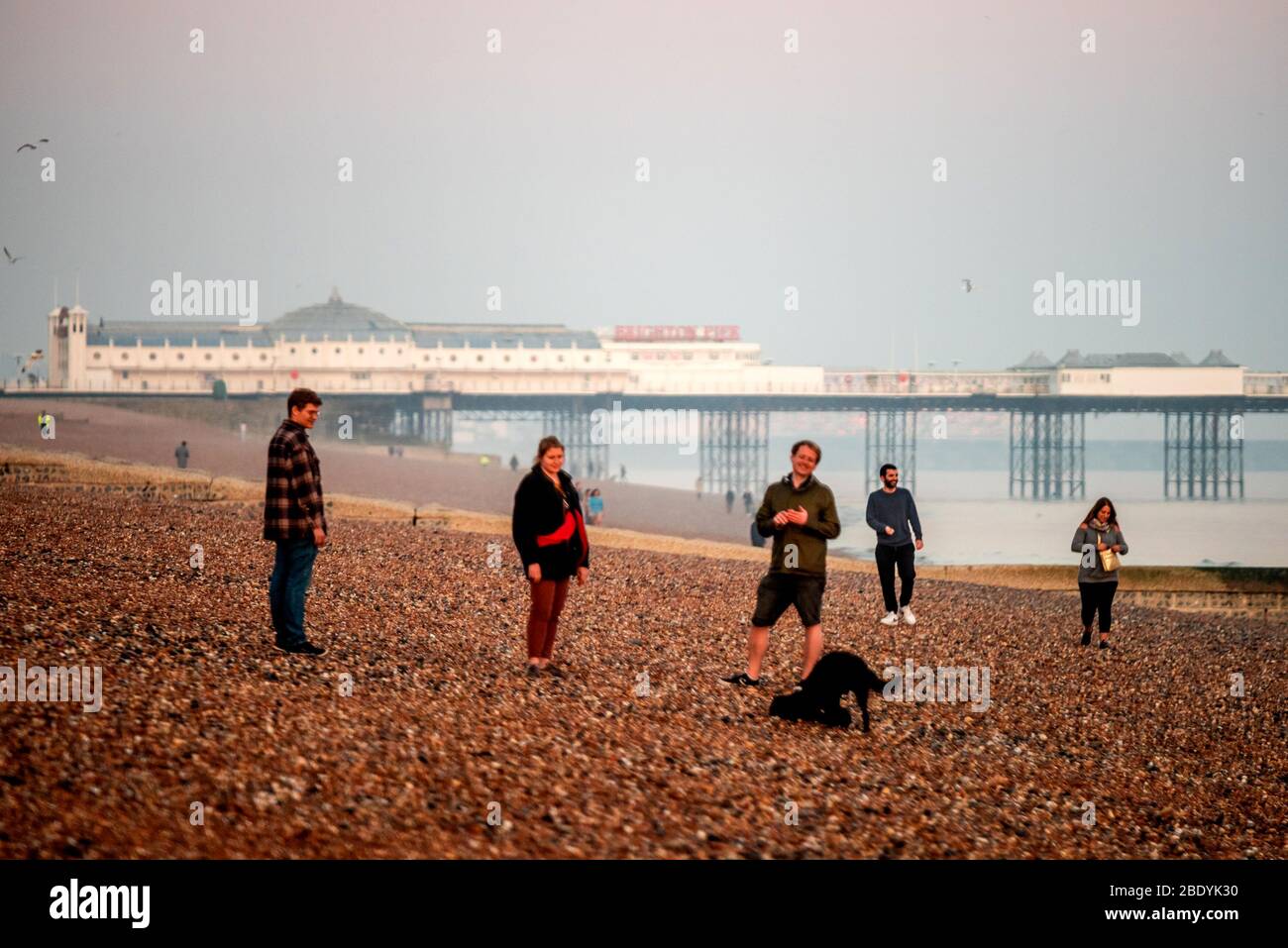 Brighton, Royaume-Uni, le 8 avril 2020, les gens de Brighton Beach qui regardent le soleil se coucher Banque D'Images