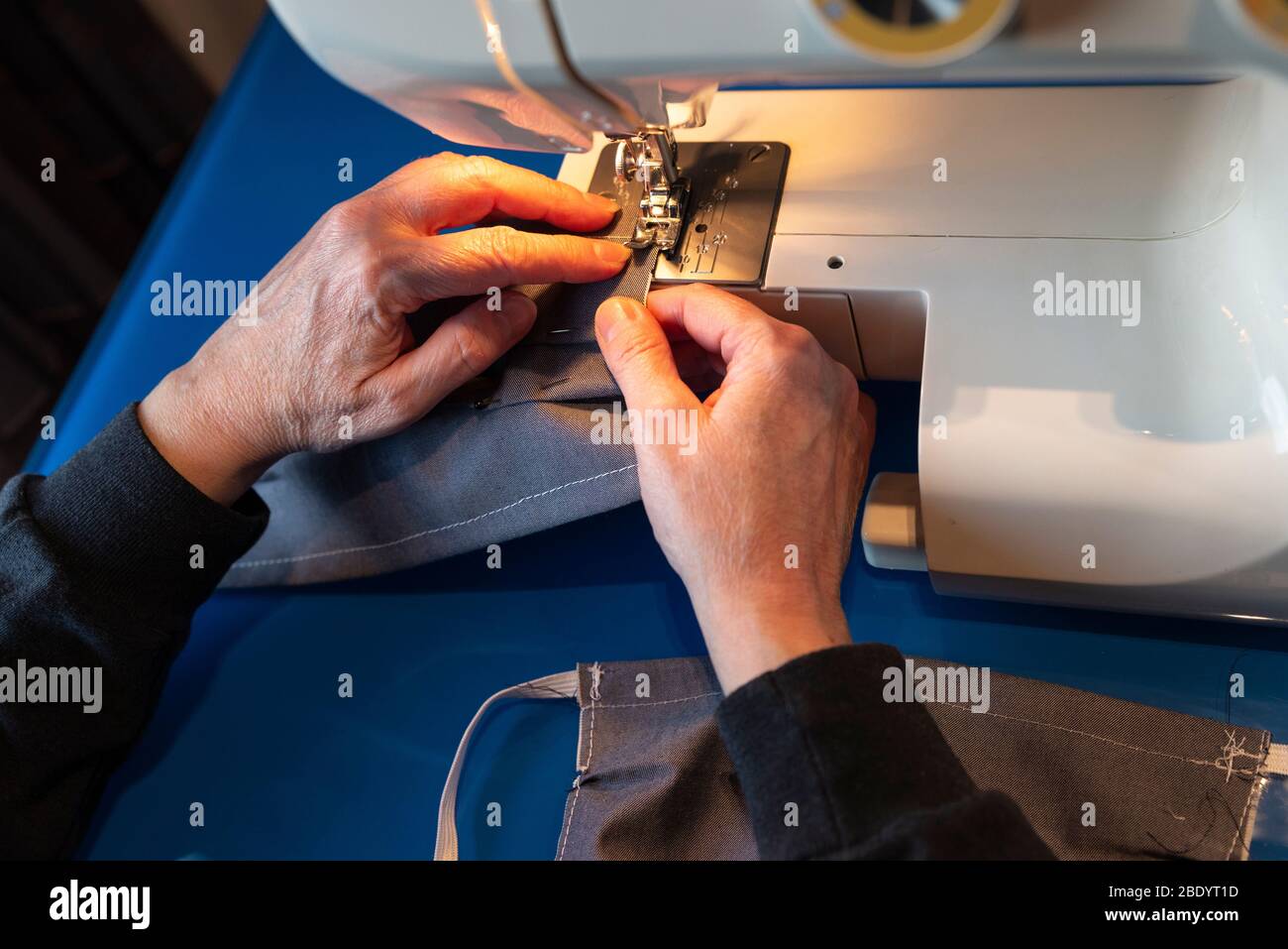 Femme couture de masques maison avec une machine à coudre à la maison pendant la quarantaine du coronavirus à Barcelone; Catalogne; Espagne Banque D'Images