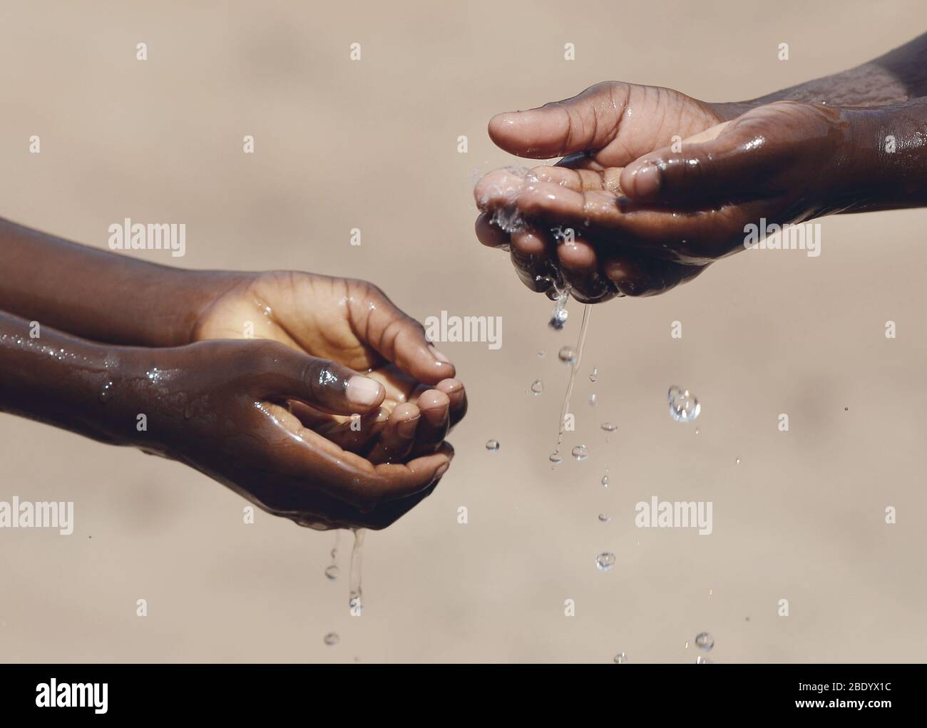 Enfants africains se laver les mains avec du désinfectant alcoolique, du savon et de l'eau pour éviter la propagation du virus Banque D'Images