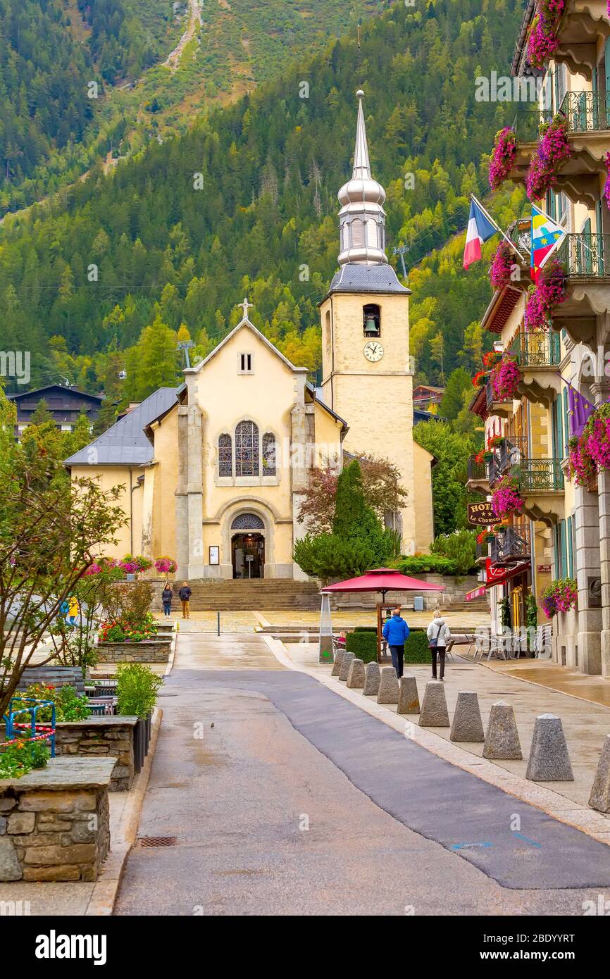 Chamonix Mont-Blanc, France - 4 octobre 2019 : les gens, l'automne vue sur la rue avec l'église catholique de St Michel en automne, fleurs et maisons de la ville Banque D'Images